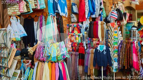 Image of Rows of colourful silk scarfs hanging at a market stall