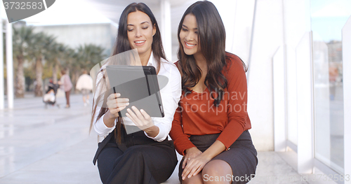 Image of Two women discussing information on a tablet