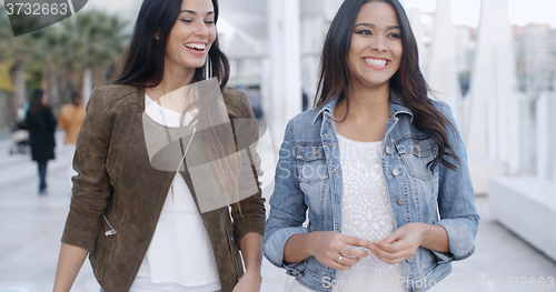 Image of Two young women strolling down a promenade