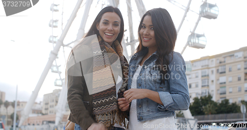 Image of Fun happy young women in front of a ferris wheel