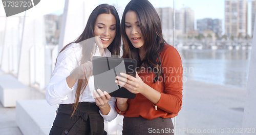 Image of Two women laughing at a tablet computer