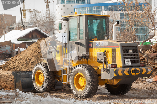 Image of Tractor removes debris from building demolition