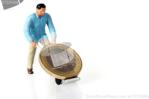 Image of Miniature worker drives euro coins