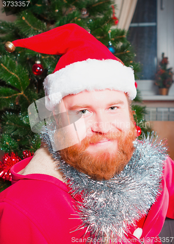 Image of A bearded man in a red suit of Santa Claus smiling