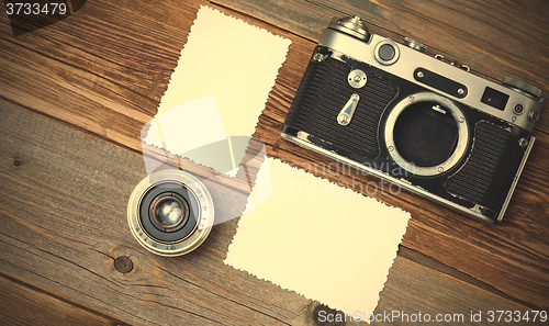 Image of retro photo mock up, vintage camera and lens on old wooden backg