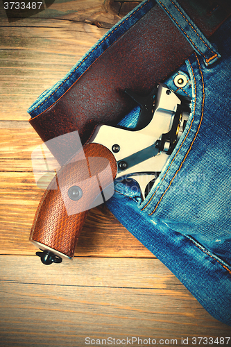 Image of silver revolver nagant with brown handle in the pocket