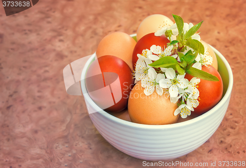 Image of Easter eggs on the table in a ceramic vase.