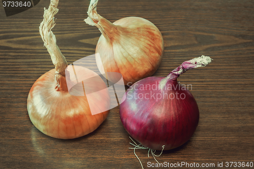 Image of Still life: three large onions on the table.