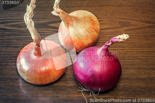 Image of Still life: three large onions on the table.