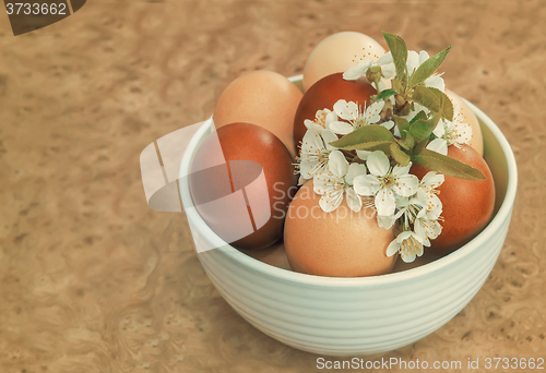 Image of Easter eggs on the table in a ceramic vase.