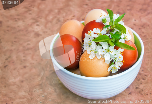 Image of Easter eggs on the table in a ceramic vase.