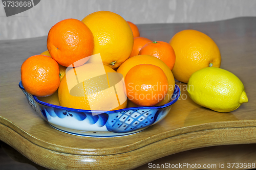 Image of Oranges and tangerines in a beautiful ceramic vase.