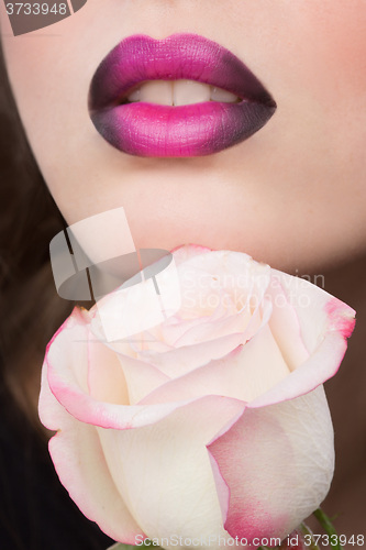 Image of Woman face with lilac Lips and Rose Flower.