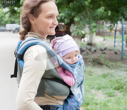 Image of The young woman with the child on sling
