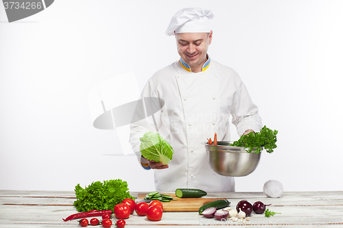 Image of Chef cooking fresh vegetable salad in his kitchen