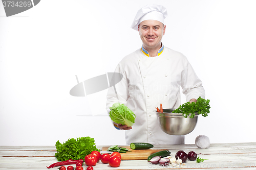 Image of Chef cooking fresh vegetable salad in his kitchen