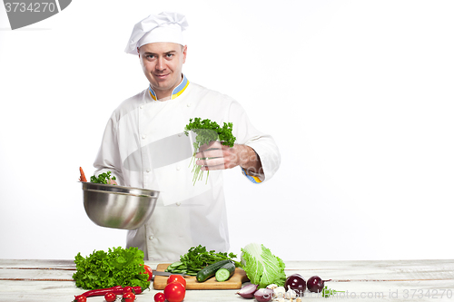 Image of Chef cooking fresh vegetable salad in his kitchen