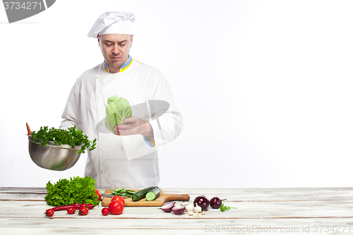 Image of Chef cooking fresh vegetable salad in his kitchen