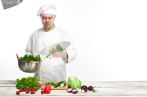 Image of Chef cooking fresh vegetable salad in his kitchen