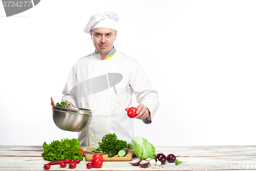 Image of Chef cooking fresh vegetable salad in his kitchen