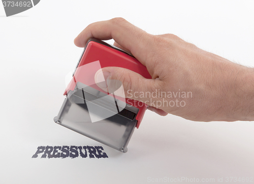 Image of Plastic stamp in hand, Pressure