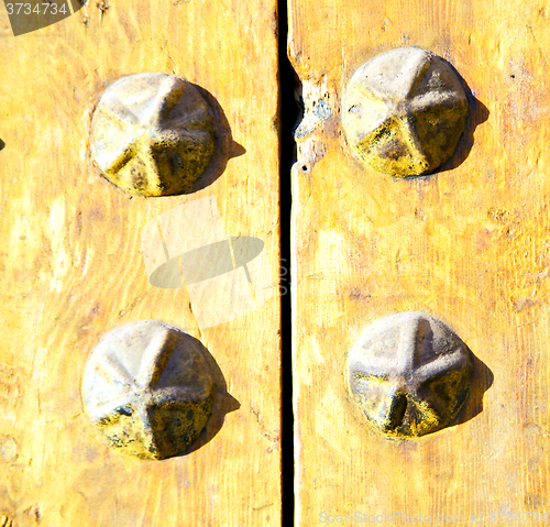 Image of metal nail dirty stripped paint in the brown   red wood door and