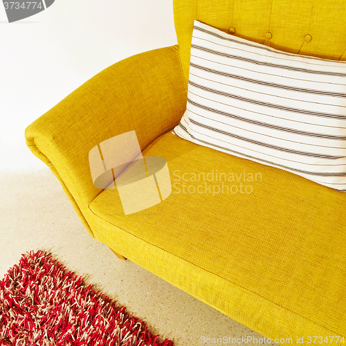 Image of Yellow sofa with striped cushion
