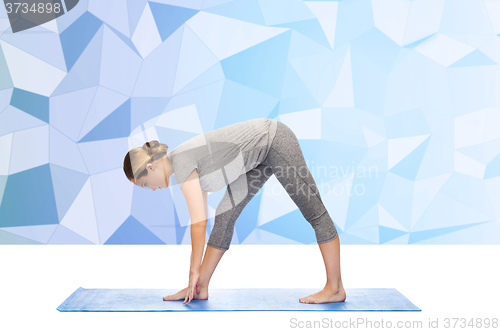 Image of woman making yoga intense stretch pose on mat