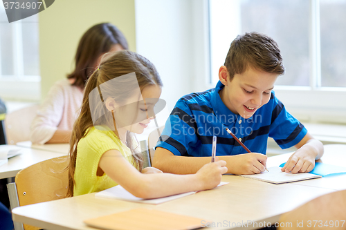 Image of group of school kids writing test in classroom