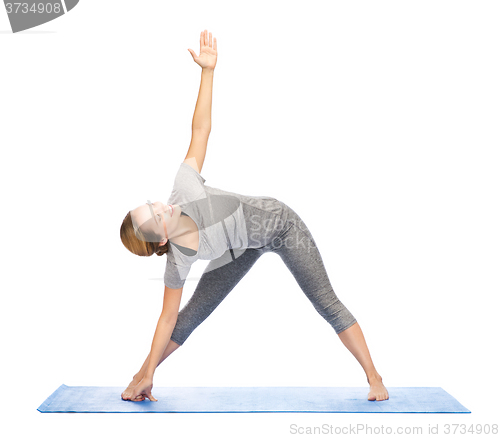 Image of woman making yoga triangle pose on mat