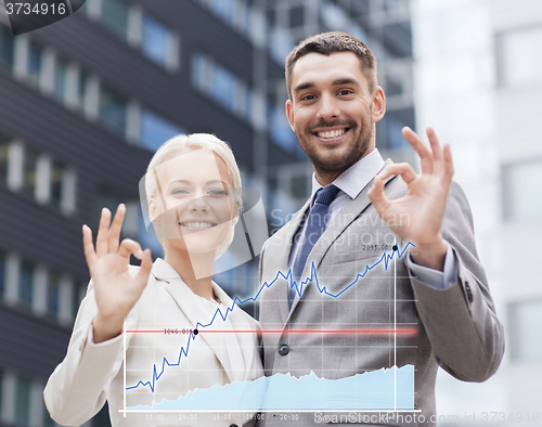 Image of smiling businessmen standing over office building