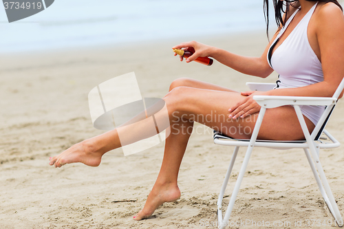 Image of close up of woman sunbathing on beach