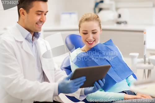 Image of male dentist with tablet pc and woman patient