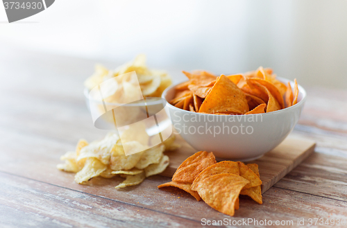 Image of close up of potato crisps and nachos in glass bowl