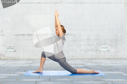 Image of happy woman making yoga in low lunge on mat