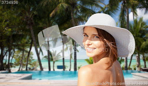 Image of happy young woman in sunhat over hotel beach