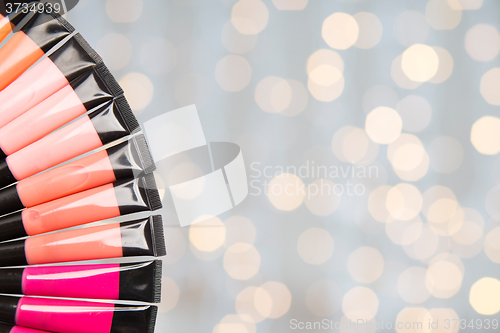 Image of close up of lip gloss tubes over lights