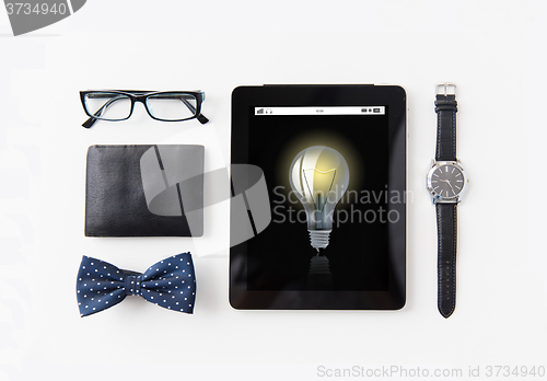 Image of tablet pc with light bulb icon and personal stuff