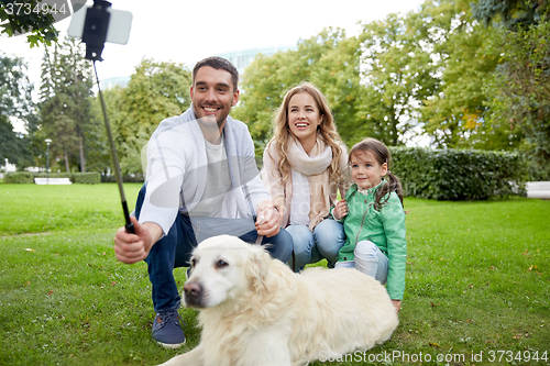 Image of happy family with dog taking selfie by smartphone