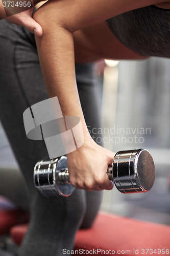 Image of close up of couple with dumbbell exercising in gym