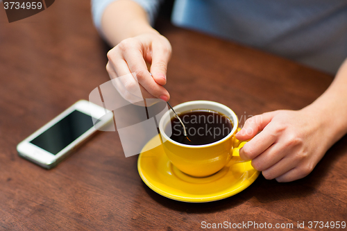 Image of close up of woman with smartphone and coffee