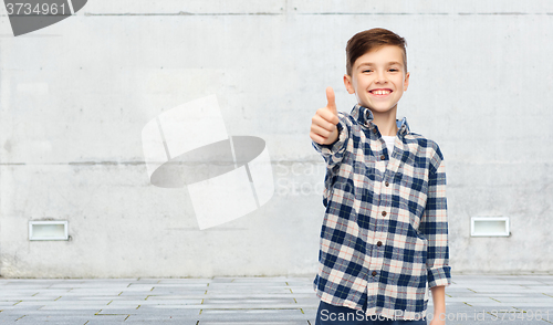 Image of smiling boy in checkered shirt showing thumbs up