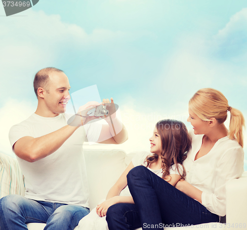 Image of happy family with camera at home