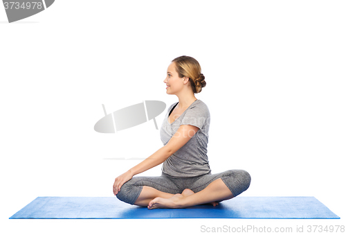 Image of woman making yoga in twist pose on mat