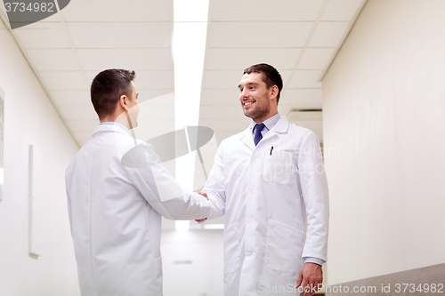 Image of smiling doctors at hospital doing handshake