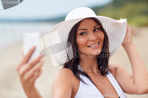 Image of young woman taking selfie with smartphone