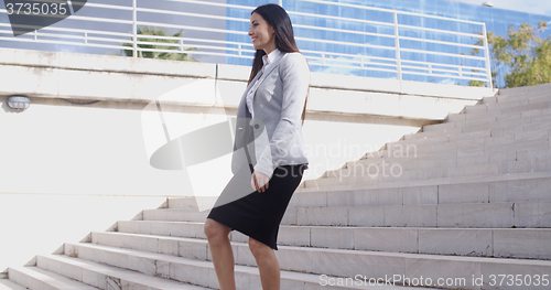 Image of Serious woman walking up staircase