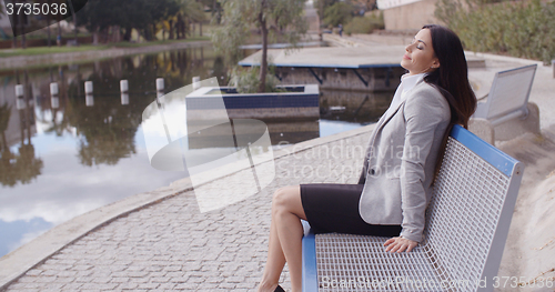 Image of Business woman relaxing near canal