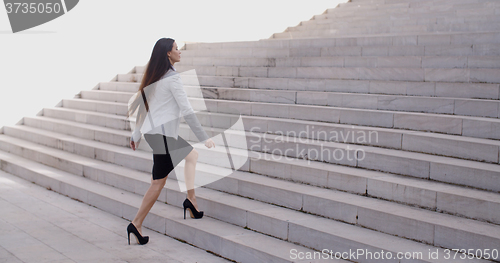 Image of Serious woman walking up staircase