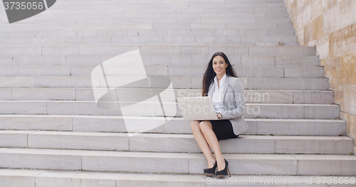 Image of Business woman with laptop on stairs